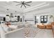 Expansive living room with tray ceilings, a modern ceiling fan, and an open concept design into the kitchen at 3850 Bonfire Dr, Odessa, FL 33556