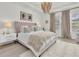 Elegant main bedroom with a decorative chandelier, tufted headboard and plush carpet flooring at 3850 Bonfire Dr, Odessa, FL 33556