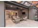 Comfortable outdoor patio with cozy seating and a view of the well-lit interior through sliding glass doors at 3850 Bonfire Dr, Odessa, FL 33556