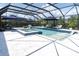 Beautiful screened-in pool with spa, umbrellas, and lounge chairs perfect for outdoor entertaining at 3850 Bonfire Dr, Odessa, FL 33556