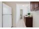 Compact kitchen space with white refrigerator and dark wood cabinets, and tile floors at 4902 Murray Hill Drive, Tampa, FL 33615