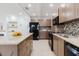 Modern kitchen with stainless steel appliances, tile backsplash, and stone countertops at 4902 Murray Hill Drive, Tampa, FL 33615