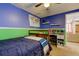 A bedroom featuring blue and green walls, a wooden bed frame, and a small desk at 4908 Rockledge Cir, Tampa, FL 33624