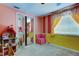 Bright room, featuring an eye-catching blend of yellow, pink and striped walls with mirror closet doors at 4908 Rockledge Cir, Tampa, FL 33624