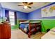 A bedroom featuring blue and green walls, a wooden bed frame, and a ceiling fan at 4908 Rockledge Cir, Tampa, FL 33624