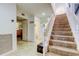 Inviting hallway with staircase, tile floors, and view into other rooms at 4908 Rockledge Cir, Tampa, FL 33624
