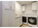 Well-equipped laundry room with modern washer, dryer, and storage cabinets at 4908 Rockledge Cir, Tampa, FL 33624