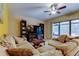 Comfortable living room with a large couch, ceiling fan, and sliding glass doors to the outside at 4908 Rockledge Cir, Tampa, FL 33624