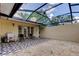 A screened in patio with a graphic outdoor rug and patio furniture at 4908 Rockledge Cir, Tampa, FL 33624