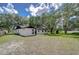 The exterior of the home as seen from the expansive backyard with mature trees at 4911 Country Aire Ln, Tampa, FL 33624