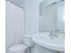 Bright bathroom featuring a toilet, sink, and shower with white fixtures at 4911 Country Aire Ln, Tampa, FL 33624