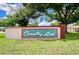 Community sign that reads 'Country Aire' with brick and trees surrounding the sign on a clear day at 4911 Country Aire Ln, Tampa, FL 33624