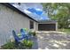 Property showing manicured garden, sitting area, textured facade and access to garage at 4911 Country Aire Ln, Tampa, FL 33624