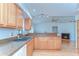 Sunlit kitchen featuring wood cabinets with granite countertops and stainless steel sink at 4911 Country Aire Ln, Tampa, FL 33624