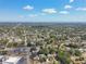Extensive aerial view of a suburban area with plentiful trees, commercial zones, and a distant glimpse of the ocean under a bright sky at 5010 8Th N Ave, St Petersburg, FL 33710