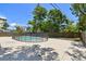 Backyard view of the pool with black safety fence with a concrete patio surrounded by trees at 5010 8Th N Ave, St Petersburg, FL 33710