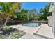 Backyard pool area featuring a safety fence, mature landscaping, and concrete patio at 5010 8Th N Ave, St Petersburg, FL 33710