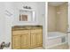 Well-lit bathroom with a double vanity, granite countertop, and a tiled bathtub at 5010 8Th N Ave, St Petersburg, FL 33710