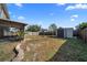 Spacious backyard featuring a shed, grass, partial fence, and screened-in porch at 5236 Treig Ln, Wesley Chapel, FL 33545