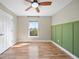 Cozy bedroom featuring wood-look flooring, fresh paint, a ceiling fan, and a bright window at 5236 Treig Ln, Wesley Chapel, FL 33545