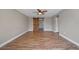 Spacious bedroom featuring hardwood floors, a ceiling fan, and a barn door leading to an attached bathroom at 5236 Treig Ln, Wesley Chapel, FL 33545