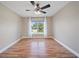 Inviting bedroom with wood-look floors, a ceiling fan, and natural light at 5236 Treig Ln, Wesley Chapel, FL 33545