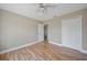 Inviting bedroom with wood-look floors, a ceiling fan, and access to closet at 5236 Treig Ln, Wesley Chapel, FL 33545