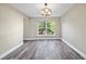 Bright dining room with hardwood floors, a modern chandelier, and a large window overlooking a beautiful landscape at 5236 Treig Ln, Wesley Chapel, FL 33545