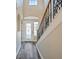 Welcoming foyer with a staircase featuring an iron railing and decorative glass door, with ample natural light at 5236 Treig Ln, Wesley Chapel, FL 33545