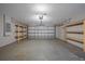 Spacious garage featuring ample room for parking and storage with shelves at 5236 Treig Ln, Wesley Chapel, FL 33545