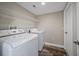 Functional laundry room equipped with a washer, dryer, and shelving for storage at 5236 Treig Ln, Wesley Chapel, FL 33545