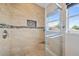 Close-up of the modern shower stall featuring stylish tile and glass enclosure with a window view at 5236 Treig Ln, Wesley Chapel, FL 33545