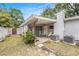 Charming backyard featuring a covered patio, comfortable rocking chairs, and mature trees, ideal for relaxing outdoors at 5250 12Th N St, St Petersburg, FL 33703