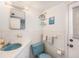 Clean and functional bathroom with vintage blue fixtures, white tile, and a corner shelf at 5250 12Th N St, St Petersburg, FL 33703