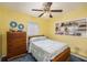 Bright bedroom with a ceiling fan, vintage furnishings, and built-in display shelves at 5250 12Th N St, St Petersburg, FL 33703