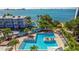Aerial view showcasing multiple pools, lush landscaping, and a building with clear blue water in the background at 5900 Shore S Blvd # 512, Gulfport, FL 33707