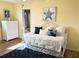 Bright bedroom featuring yellow walls, white furniture, and coastal-themed decorations, creating a cheerful ambiance at 5900 Shore S Blvd # 512, Gulfport, FL 33707
