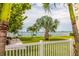 Picturesque community grounds featuring a white fence, palm trees, and serene water views, ideal for outdoor enjoyment at 5900 Shore S Blvd # 512, Gulfport, FL 33707