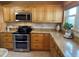 Kitchen with stainless steel appliances, granite countertops, tile backsplash, and warm wood cabinets at 5900 Shore S Blvd # 512, Gulfport, FL 33707