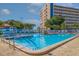 Outdoor swimming pool with bright blue water and high-rise building and palm trees in the background at 5900 Shore S Blvd # 512, Gulfport, FL 33707