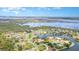 Aerial view of waterfront homes on a waterway, with a bridge to a distant coastal city in the background at 6120 9Th Avenue Ne Cir, Bradenton, FL 34212