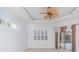 Bedroom with white shutters, tray ceiling with fan, and sliding door access to the pool at 6120 9Th Avenue Ne Cir, Bradenton, FL 34212