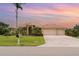 Beautiful single-story home featuring a terracotta roof, lush landscaping, a brick-paved driveway, and a two-car garage at 6120 9Th Avenue Ne Cir, Bradenton, FL 34212