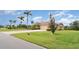 A beautifully landscaped single-story home featuring a terracotta roof, a paved driveway, and a spacious lawn at 6120 9Th Avenue Ne Cir, Bradenton, FL 34212