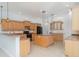 Open-concept kitchen featuring granite counters, wood cabinets, a center island, and tile flooring at 6120 9Th Avenue Ne Cir, Bradenton, FL 34212