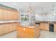 Well-lit kitchen equipped with an island, wood cabinets, granite countertops, and modern appliances at 6120 9Th Avenue Ne Cir, Bradenton, FL 34212