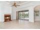 Open living room features a red brick fireplace and glass sliding door access to a screened-in pool at 6120 9Th Avenue Ne Cir, Bradenton, FL 34212