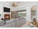 A sunlit living room featuring a marble fireplace, tile floors, and sliding glass doors to a lanai and pool at 6120 9Th Avenue Ne Cir, Bradenton, FL 34212