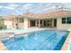 Relaxing screened-in pool area featuring a spa and water fountain with backyard access from the home at 6120 9Th Avenue Ne Cir, Bradenton, FL 34212