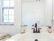 This bathroom has a large mirror, a white sink, and a window for natural light at 717 Fairmont Dr, Brandon, FL 33511